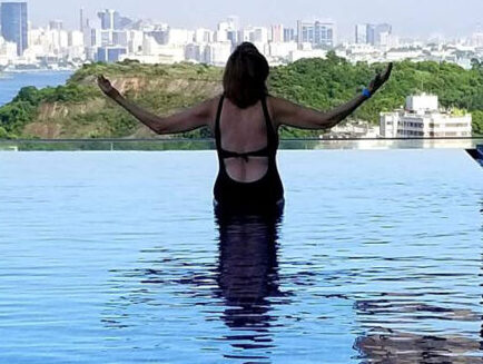 A man holding a flute, smiling warmly in a formal setting.